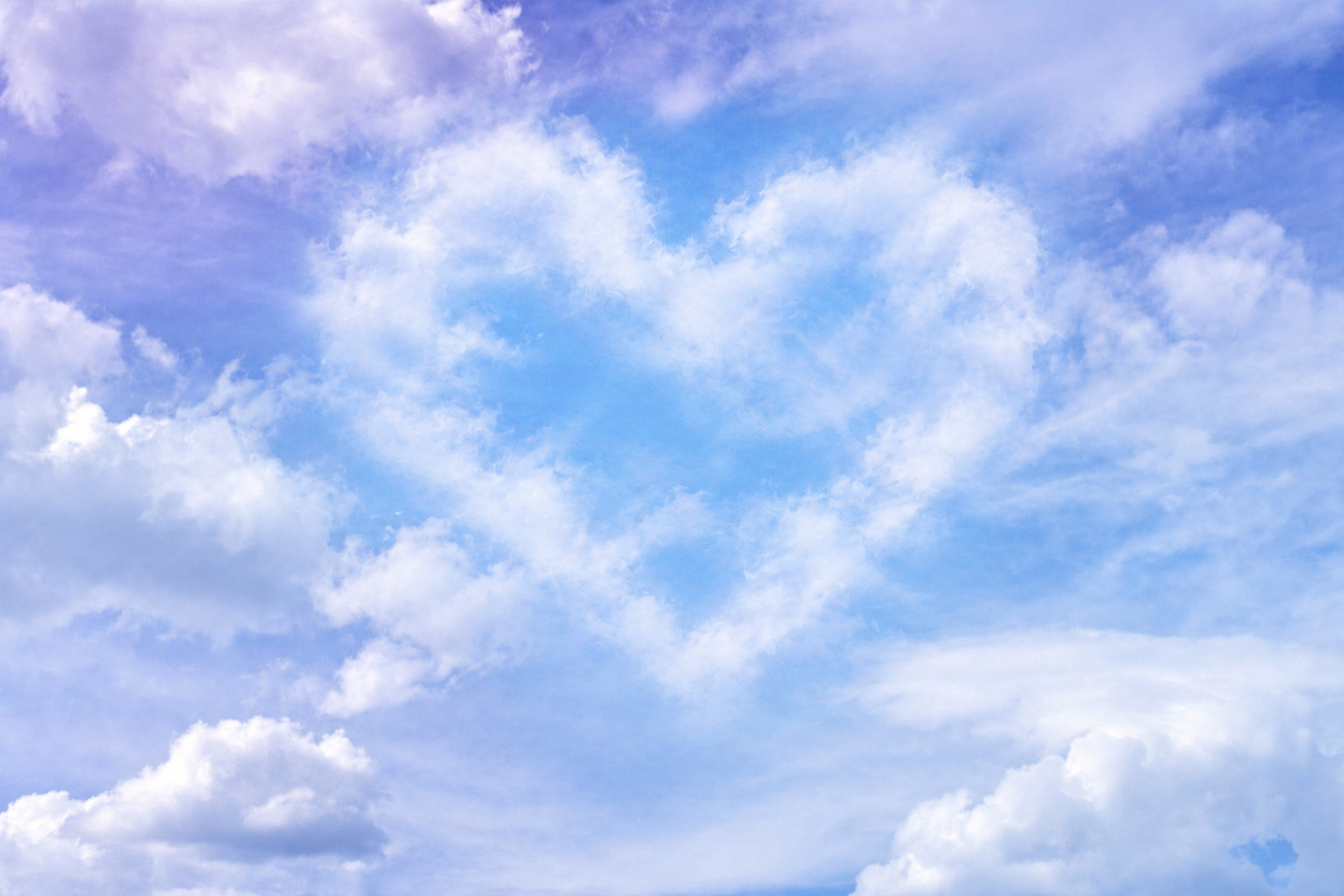 A soft heart-shaped cloud in a blue and lavender sky